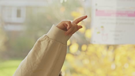 Close up of child&#039;s finger raised in classroom on a sunny day