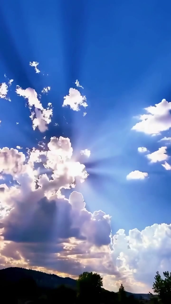 Sinar Matahari Memancar Menembus Awan di Langit Biru