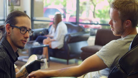 Man-Sits-In-Chair-Having-Tattoo-In-Parlor-Shot-On-R3D