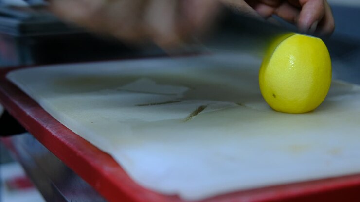 Male hand cutting lemon counter