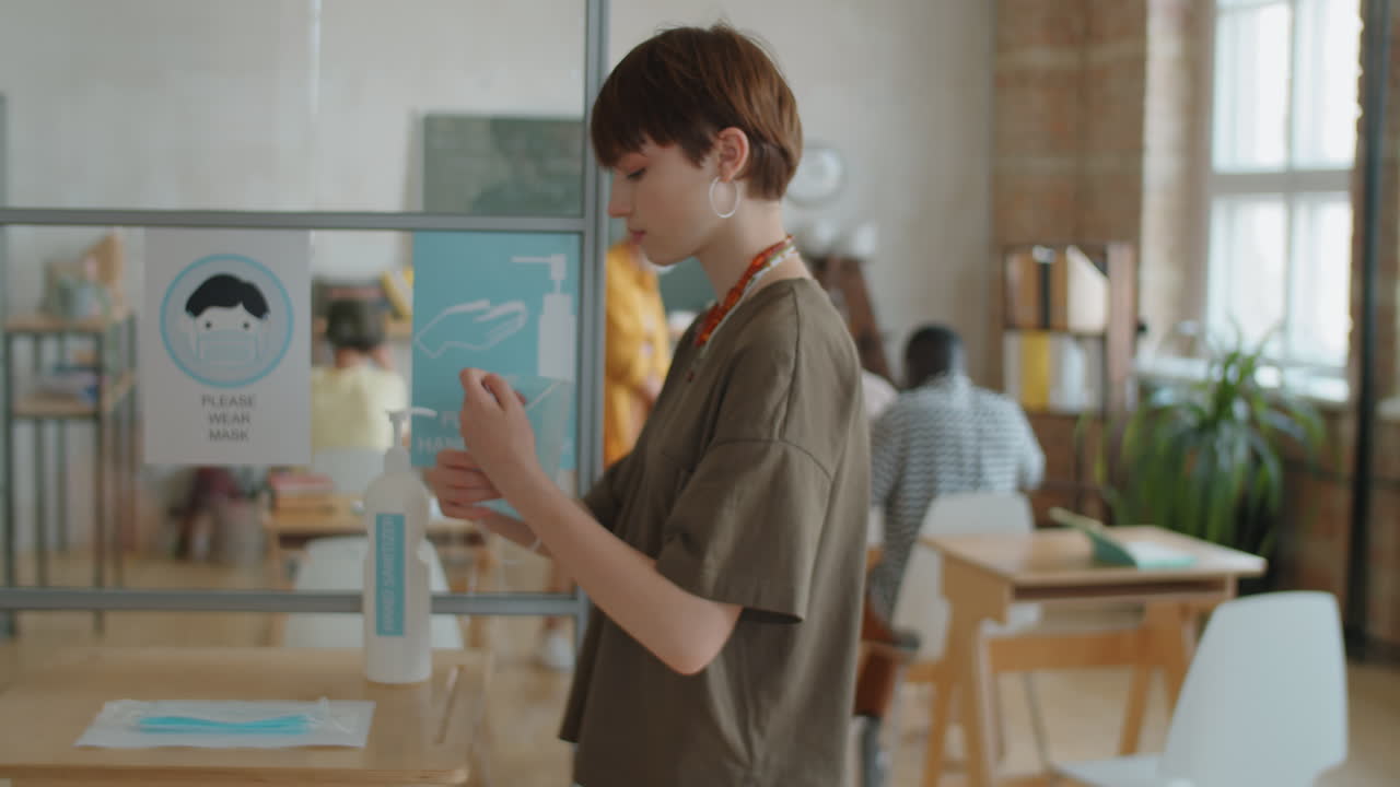 los estudiantes se ponen máscaras y aplican desinfectante para manos antes de la lección