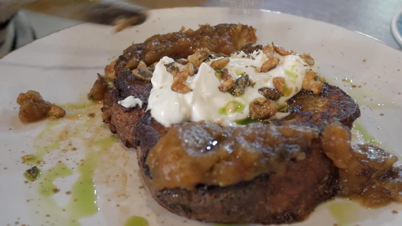 Freshly made French toast topped with creamy yogurt, caramelized apples, and crushed nuts