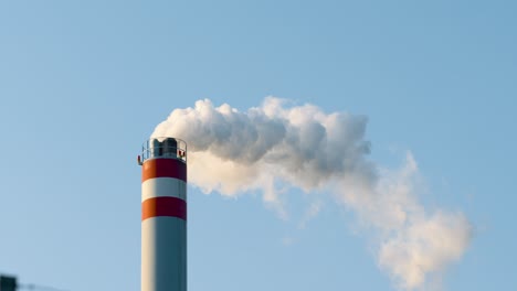 white smoke air pollution coming from the pipes on an industrial factory