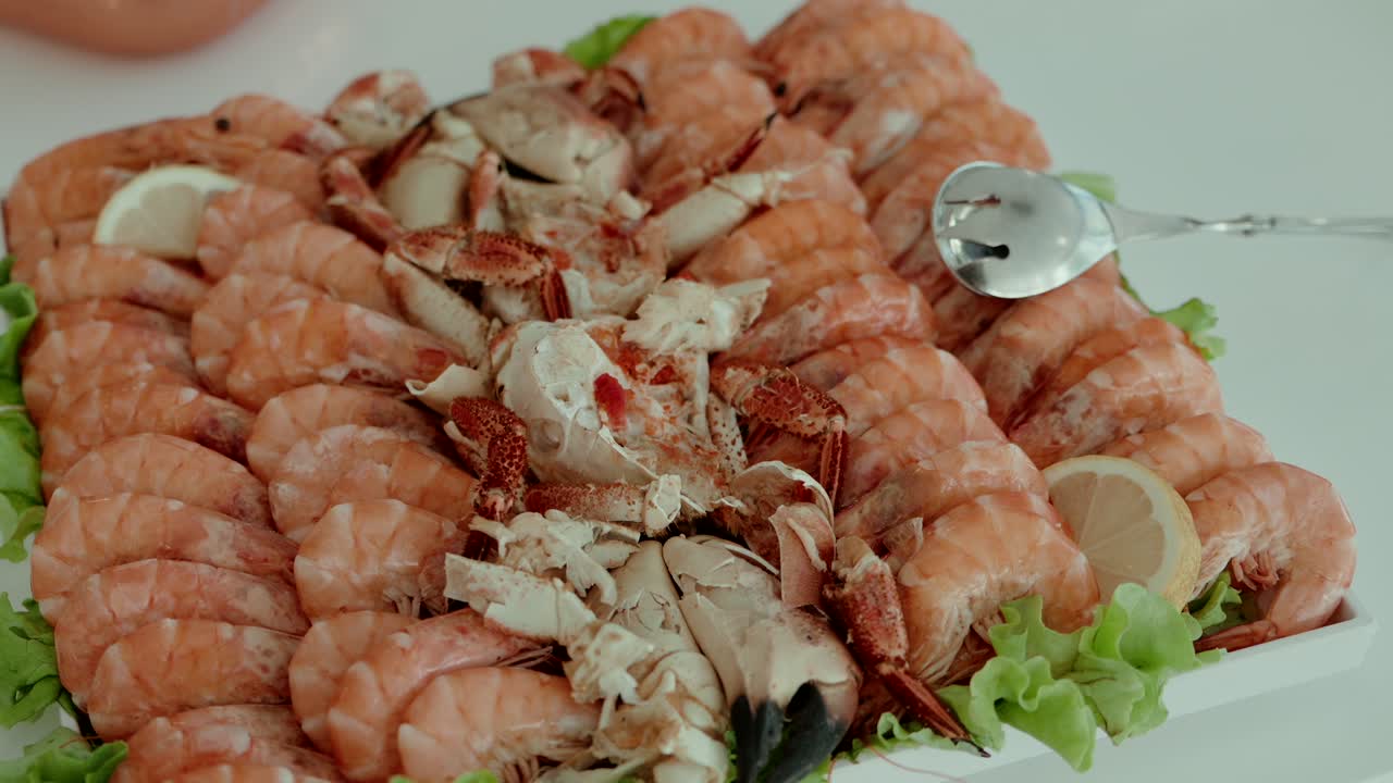 fresh prawns and crab claws arranged on lettuce with lemon slices