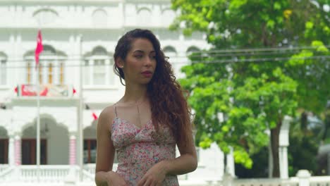 Close-up-of-a-young-curly-hair-woman-walking-in-a-park-with-a-castle-in-the-background