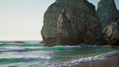 stone rock portugal ursa beach washed calm atlantic ocean. view of high cliff.