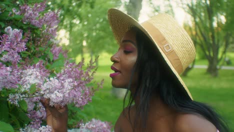 black woman smelling flowers lilacs close up