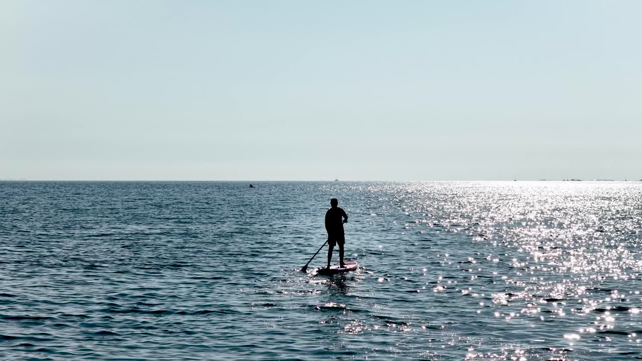 Man paddle boarding on calm ocean water