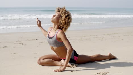 mujer practicando yoga en la playa