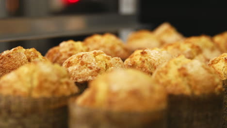 A-baking-tray-of-freshly-baked-muffins-at-a-bakery,-close-up