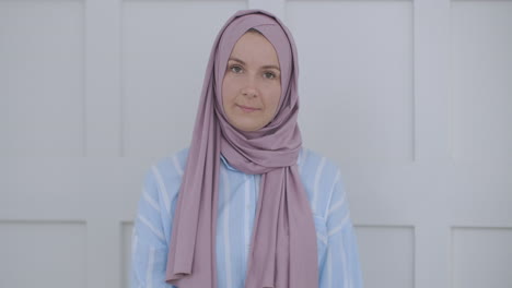 In-Die-Kamera-Schauend-Und-Mit-Dem-Kopf-Nickend,-Spricht-Eine-Muslimische-Frau-Im-Hijab-über-Eine-Videoübertragung-Und-Hört-Sich-Einen-Vortrag-An.-Remote-Videogespräch