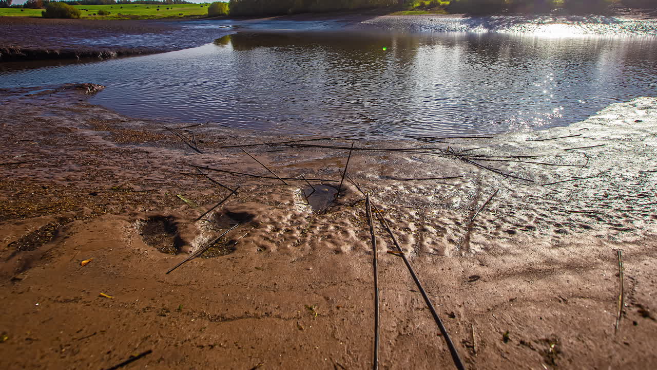 일몰 시 갯벌이 있는 썰물 강의 저속