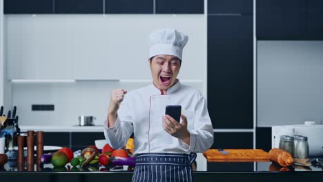 chef feliz celebrando en su teléfono inteligente