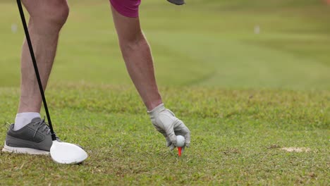 golfer executing a tee shot on the course.