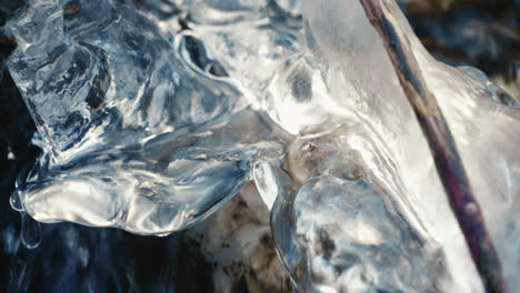 ice and icicle in a frozen river in winter with flowing water, close up, slow motion