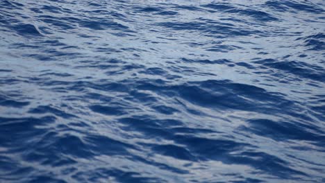 Sailing-on-Wavy-Ocean,-Cinematic-Slow-Motion,-Blue-Water-Surface-at-Twilight,-Full-Frame