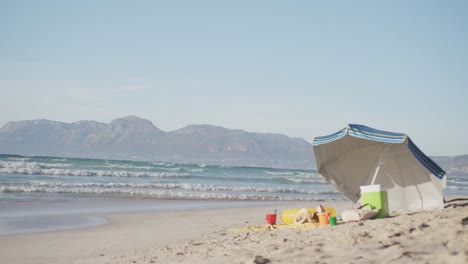 View-of-umbrella,-san-buckets,-hats-and-blanket-on-the-beach