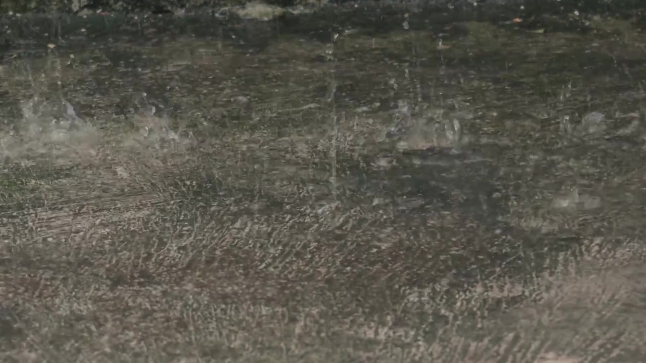 Raindrops Splashing on Wet Concrete Surface During Heavy Rain