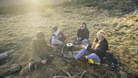 group of friends preparing food in mountains