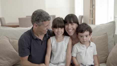 padres feliz pareja y niños viendo una película en la televisión