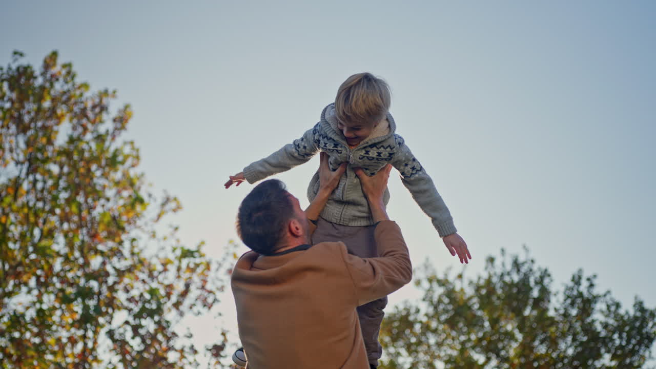 Un padre lancia in aria suo figlio