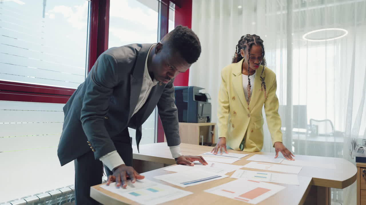 dos hombres de negocios están examinando documentos en la oficina un hombre y una mujer negros abogados