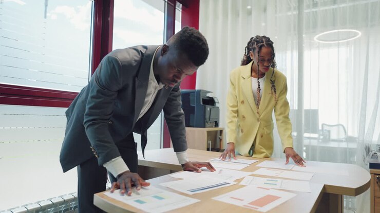two businesspersons are examining documents in office black man and woman lawyers