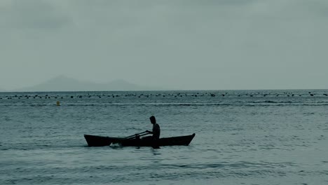 fisherman on a boat is rowing fast to avoid storm