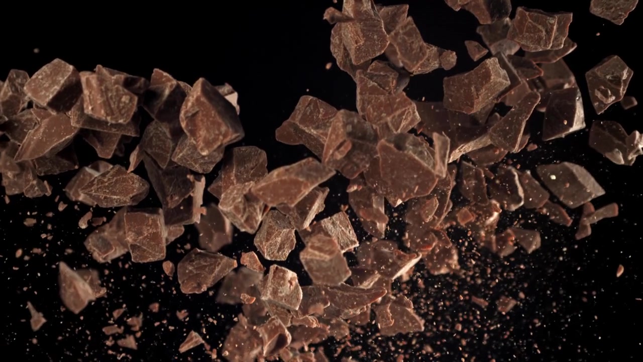 黒い背景に落下するチョコレートの破片の超スローモーション