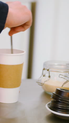 camarero haciendo una taza de café en una mesa de acero