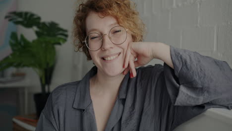 mujer sonriente con cabello rizado y gafas