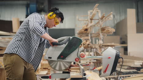 carpenter using a circular saw in a workshop