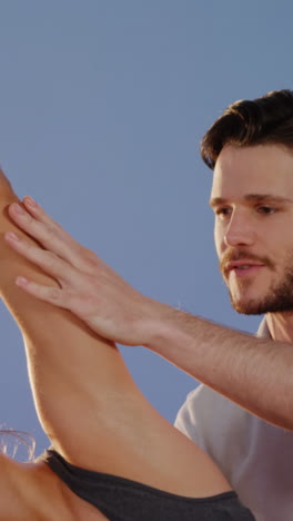 physiotherapist assisting woman while exercising