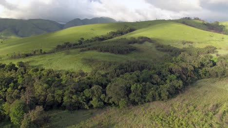 4K-Drohnenaufnahmen-Aus-Der-Luft,-Die-An-Einem-Schönen-Tag-über-üppige-Grüne-Waldhügel-Fliegen