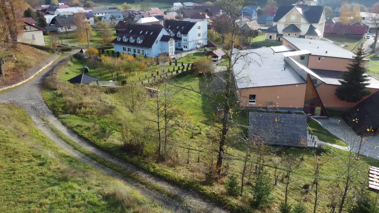 Droneutsikt over fjellandsby med kirke og omkringliggende åser