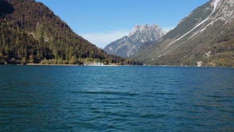 peaceful glacier lake lago del predil surrounded by towering mountains, aerial