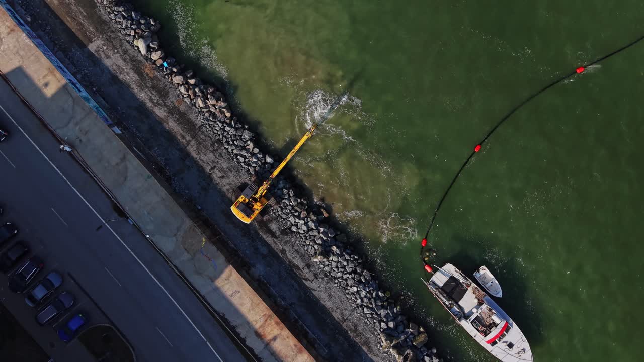 Vista dall'alto di un escavatore e di una barca sulla riva del porto di Burgas.