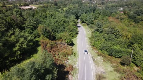 Luftaufnahme-Der-Straße,-Die-Am-Schwarzen-Meer-Entlang-Der-Natur-Vorbeiführt,-Mit-Autos-Und-Lastwagen,-Die-Zwischen-Grünen-Wiesen-Vorbeifahren,-Sonniges-Wetter,-Sonne,-Wetter-Am-Nachmittag