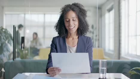retrato de una feliz mujer de negocios biracial haciendo una videollamada en la oficina, cámara lenta