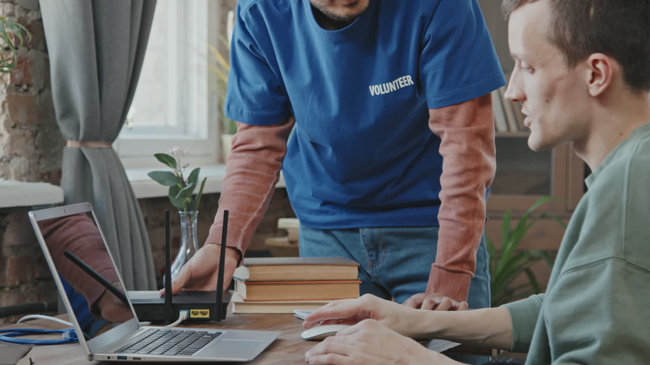 Volunteer Doing Wi-Fi Router Setup for Man with Disability