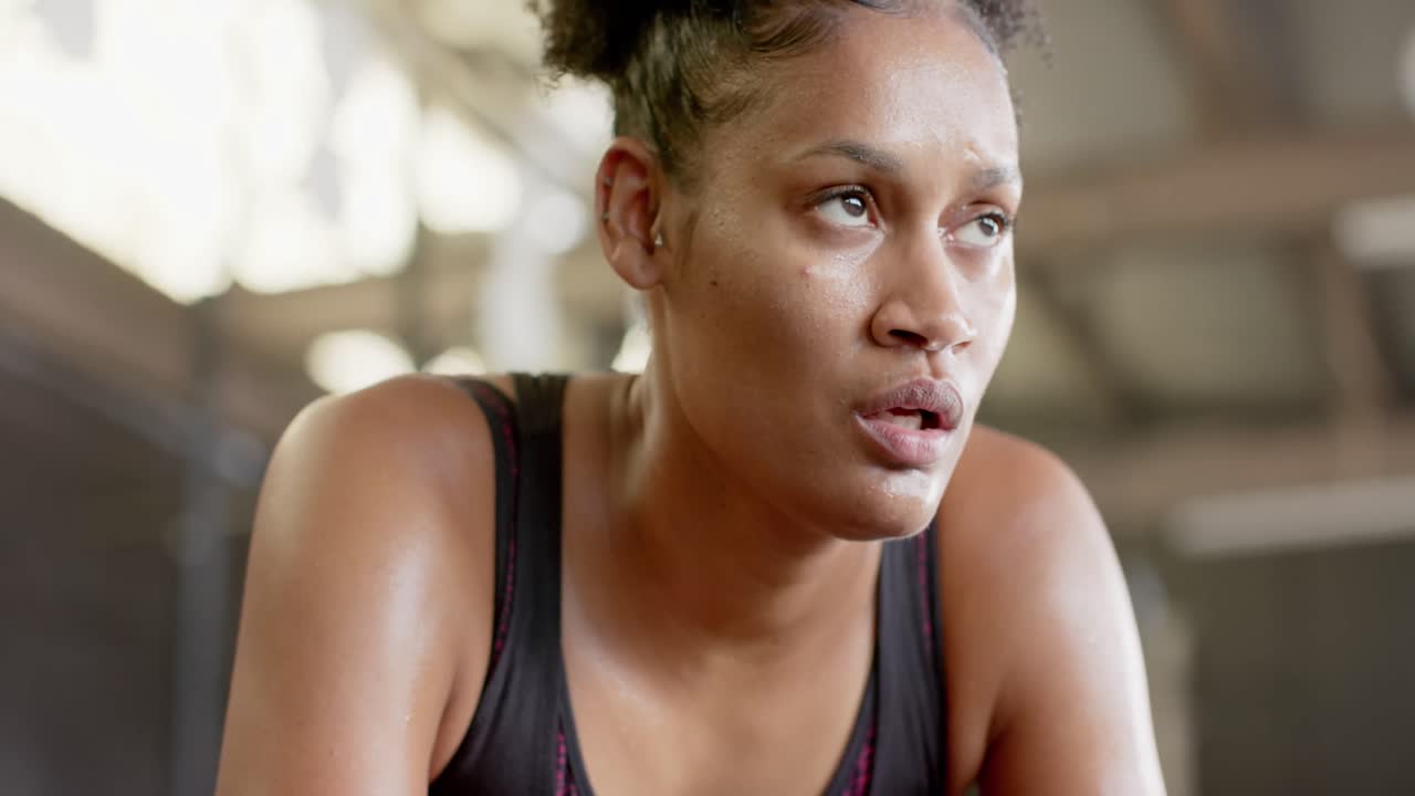 Tired african american woman resting after training at gym in slow motion