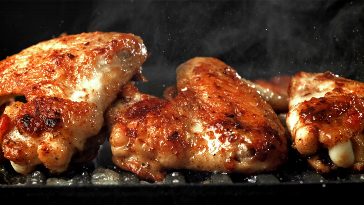 Deliziose ali di pollo sfrigolanti su una griglia calda