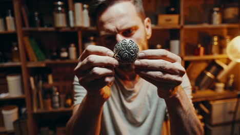artisan creating a decorative metal pendant in a workshop