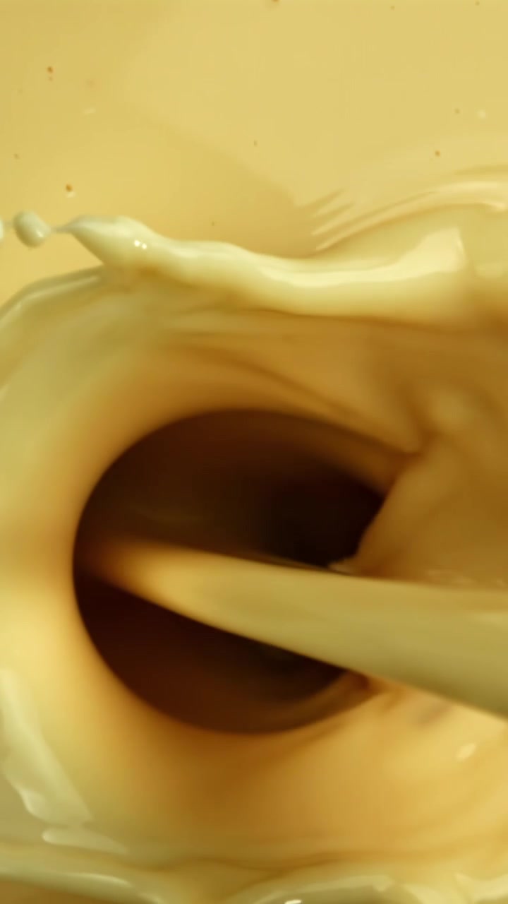 Slow Motion Close-Up of Creamy Liquid Pouring and Mixing