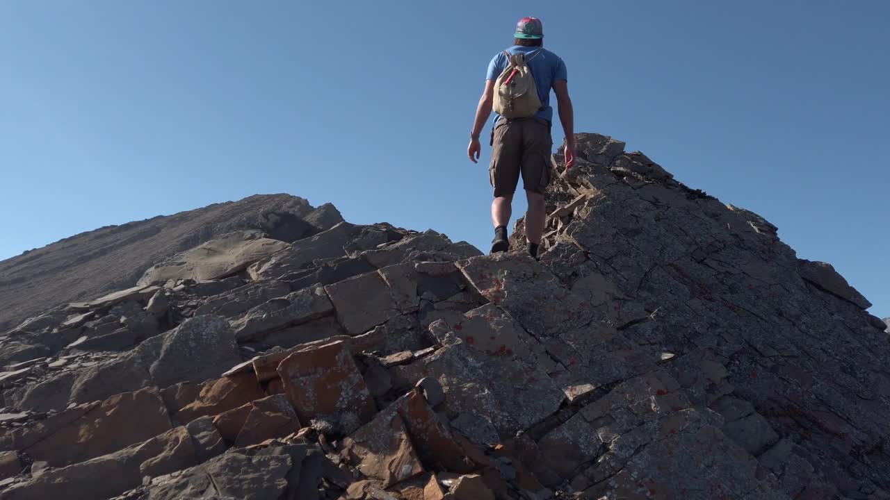 excursionista escalando roca de montaña esperando cámara lenta kananaskis alberta canadá