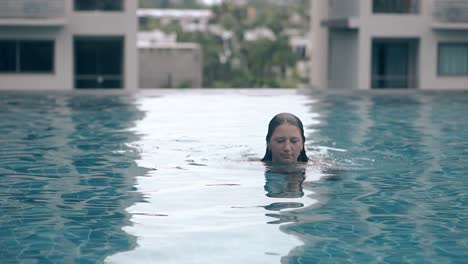 pretty-woman-in-bikini-swims-in-pool-on-roof-slow-motion