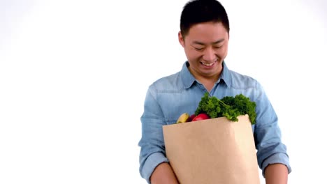 asian smiling man holding a food bag