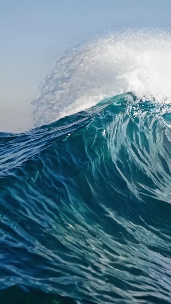 Dynamic video captures a powerful ocean wave from a low-angle perspective, emphasizing the wave's