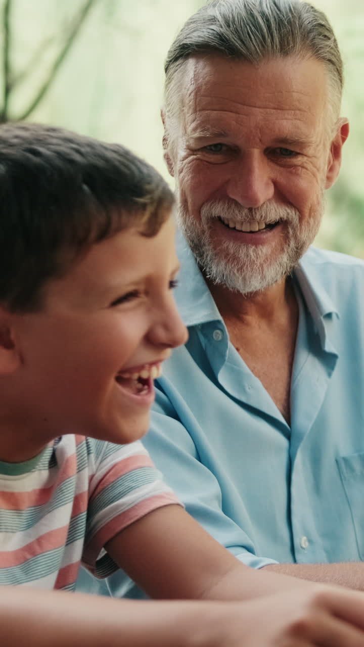 Abuelo y nieto felices riendo juntos al aire libre