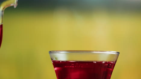 red liquid being poured into a glass